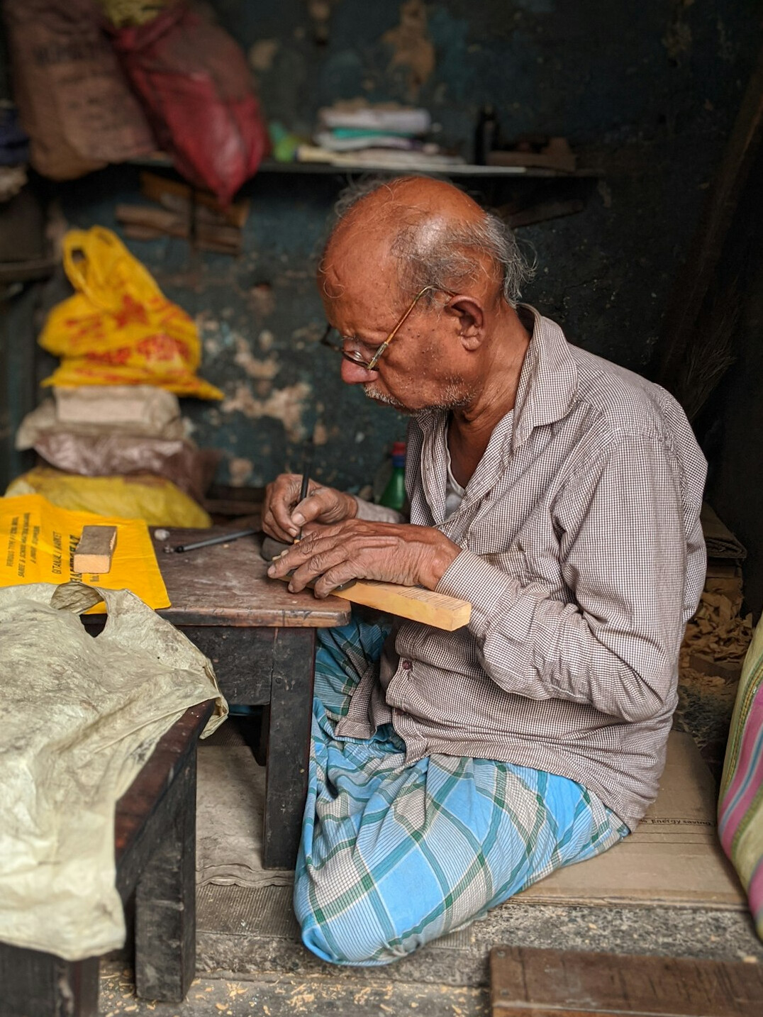 Elderly Polish craftsman working with wood in his countryside workshop